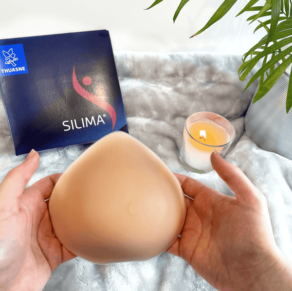 Ultra Light Breast Form prosthesis held in hands, featuring lightweight silicone for comfort. Ideal for post-mastectomy and sensitive skin.