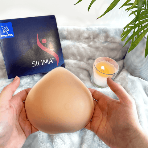 Ultra Light Breast Form prosthesis held in hands, featuring lightweight silicone for comfort. Ideal for post-mastectomy and sensitive skin.